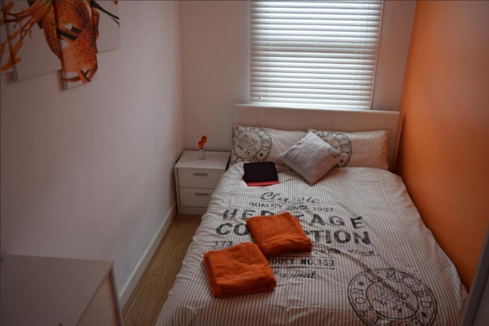 伦敦03 Bedroom Apartment-Self Check in的一间卧室配有带橙色枕头的床