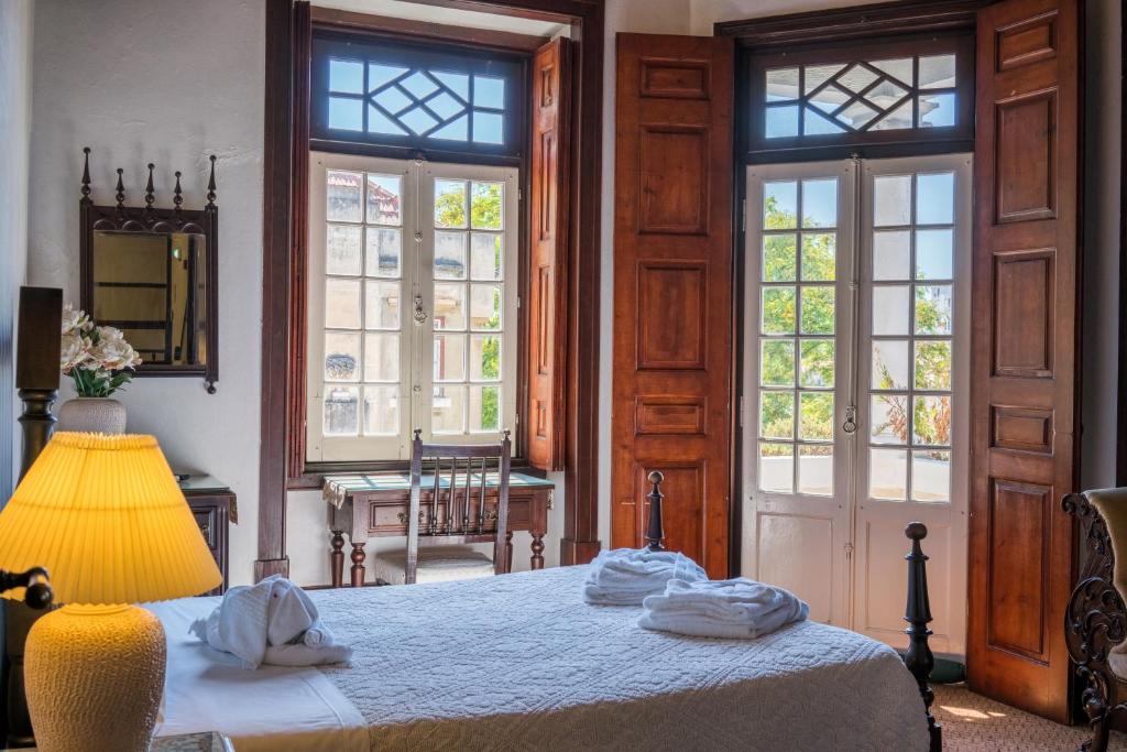 科英布拉阿连特亚纳住宅酒店的一间卧室配有一张带灯和窗户的床