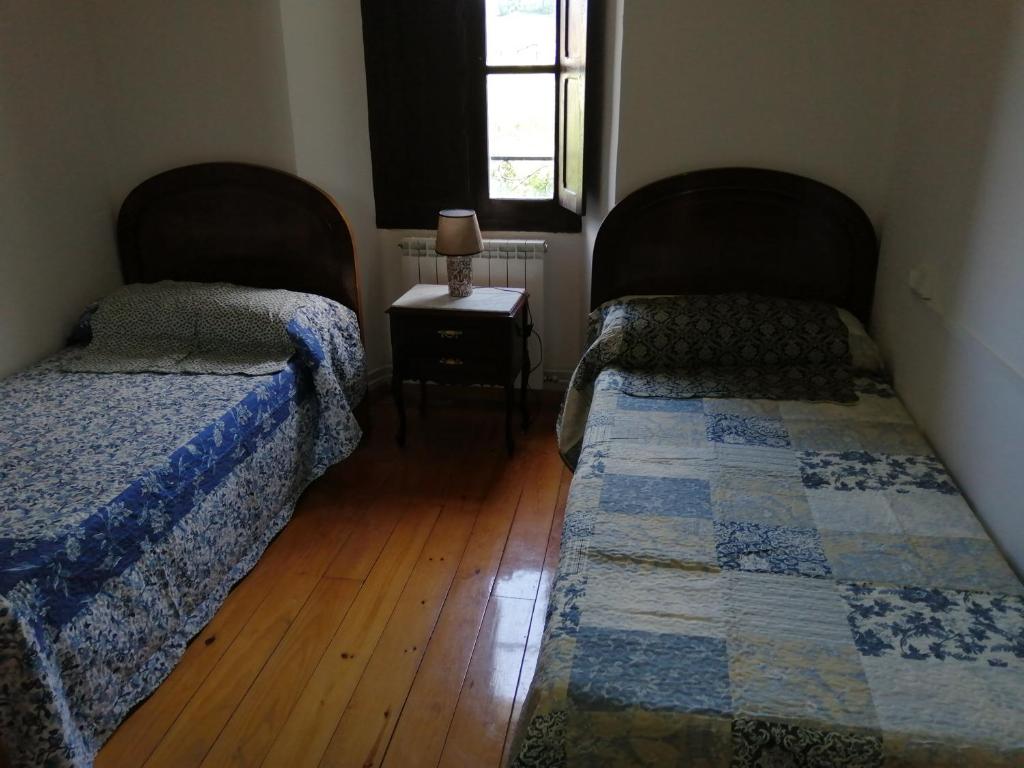 Beinza-LabayenLabaiengo Ostatua的一间卧室设有两张床和一张桌子及窗户