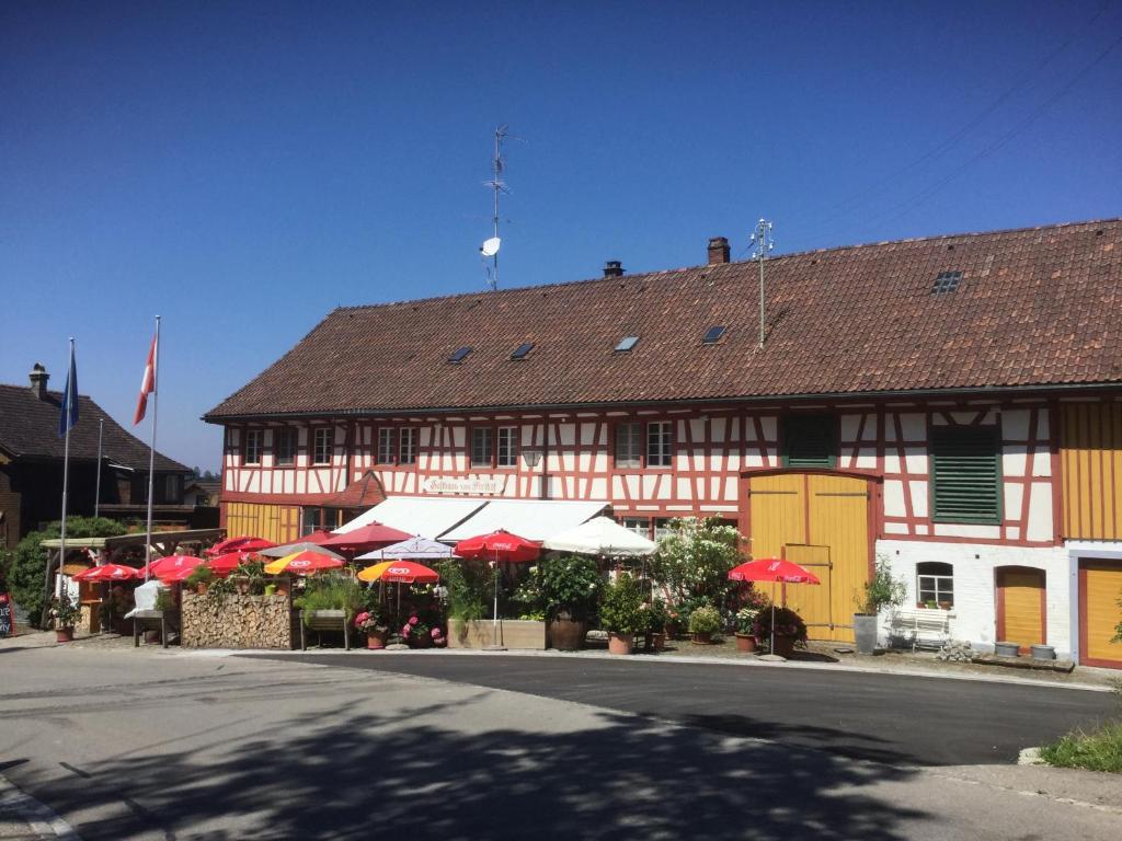 Gasthaus Freihof的前面有红白雨伞的建筑