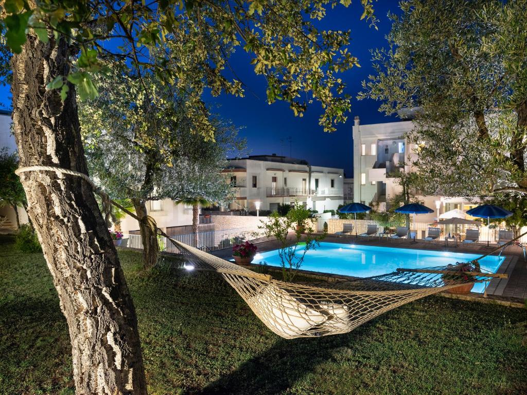 阿尔贝罗贝洛Hotel Colle Del Sole的悬在泳池旁树上的吊床