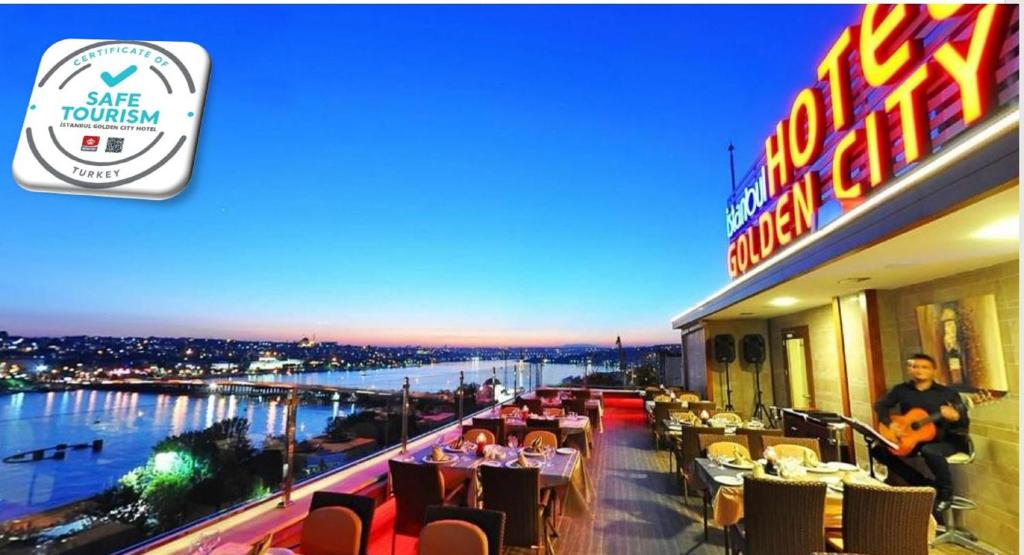 伊斯坦布尔伊斯坦布尔金城大酒店的一间享有河景的餐厅,以及坐在桌子上的人