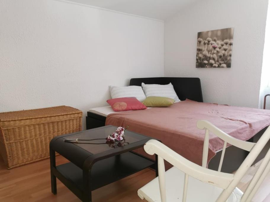 伦达瓦APARTMA LINDAU的一间卧室配有一张床、一把椅子和一张桌子
