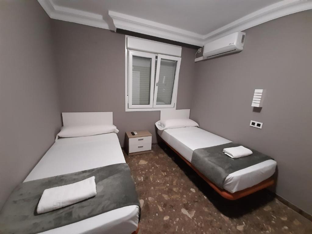 阿亚蒙特AYAMONTE ROOMS 43的客房设有两张床和窗户。