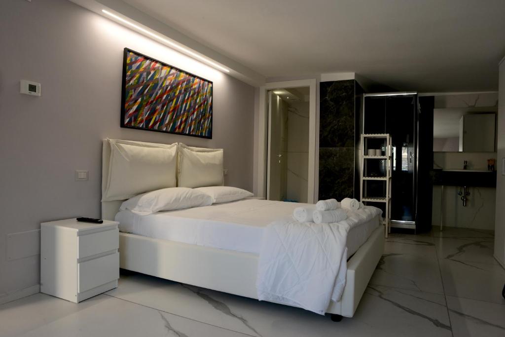 马泰拉Dimore Pietrapenta Apartments, Suites & Rooms - Via Lucana 223, Via Piave 23, Via Chiancalata 16的卧室配有一张白色床,墙上挂有绘画作品