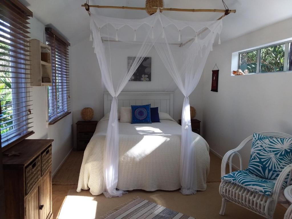 科罗曼德镇Bali Haven的一间卧室配有一张带天蓬的白色床