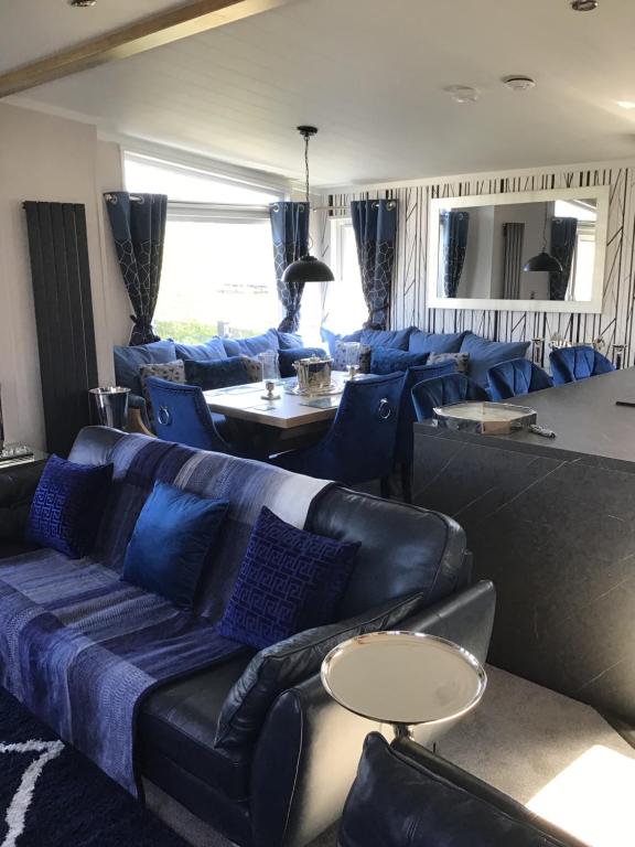 斯凯格内斯Southview VIP Lodge Skegness Stunning setting and location Outdoor decking area fitted to a 5 star standard的客厅配有蓝色的沙发和椅子
