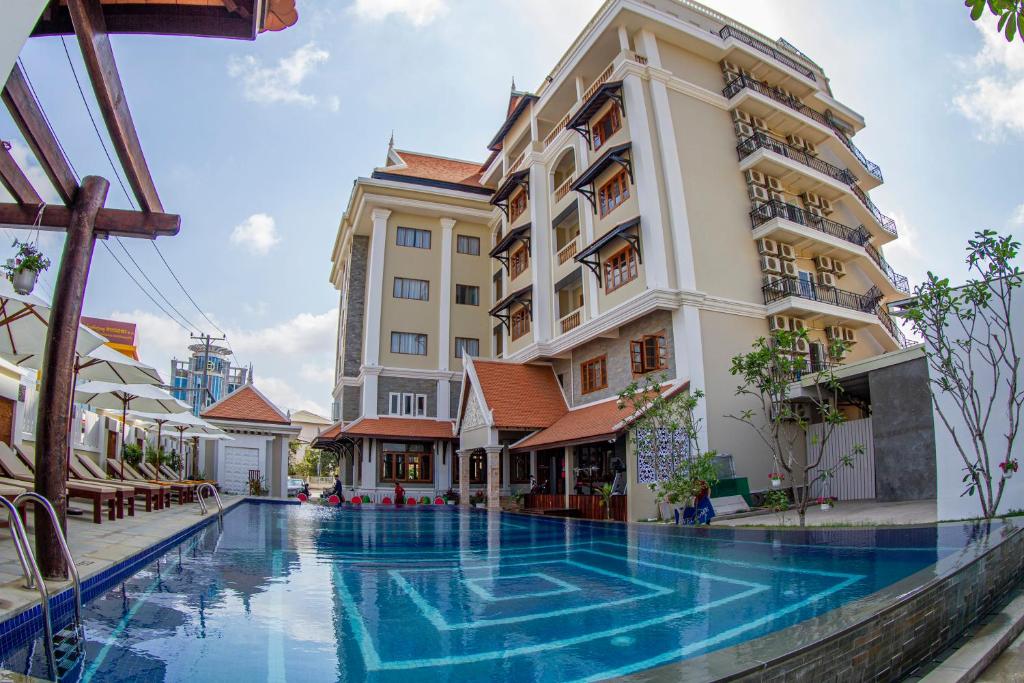 磅同省Kampong Thom Palace Hotel的大楼前设有游泳池的酒店