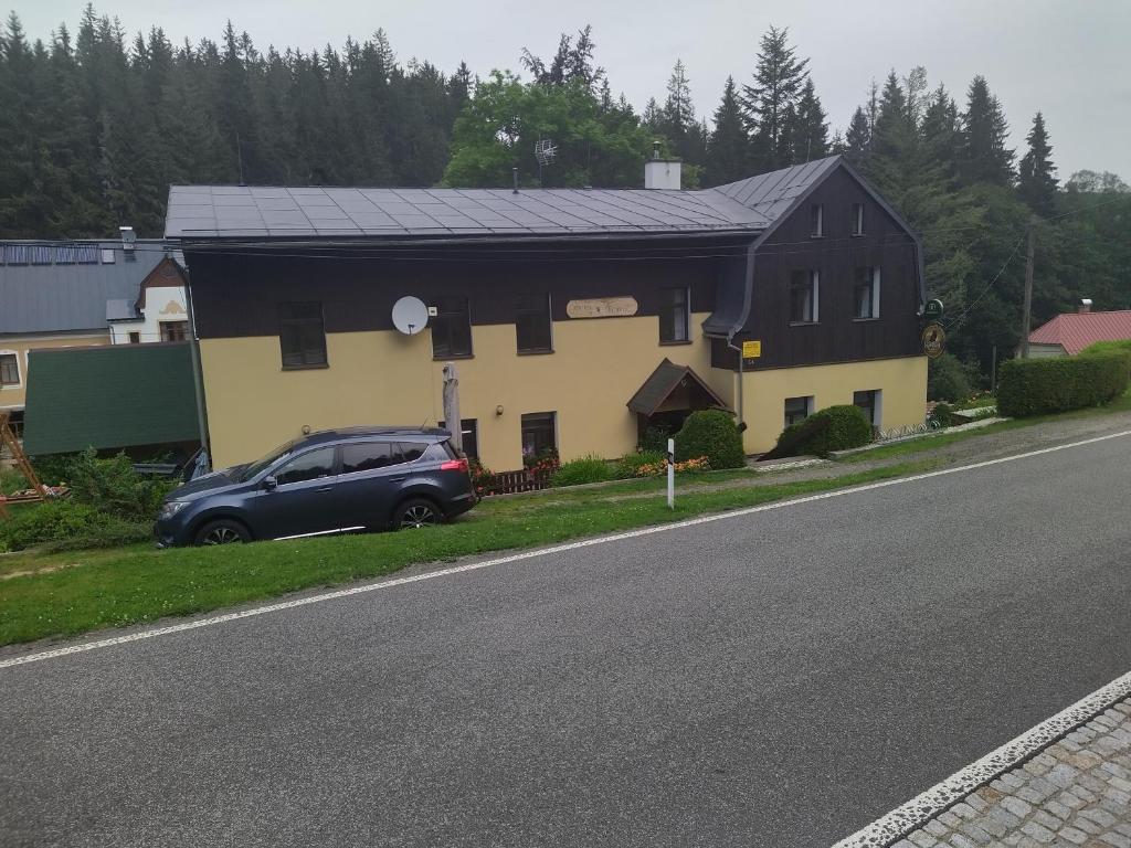 约瑟夫杜尔Penzion Borovice的一辆黑色和黄色的房子,路边有一辆汽车
