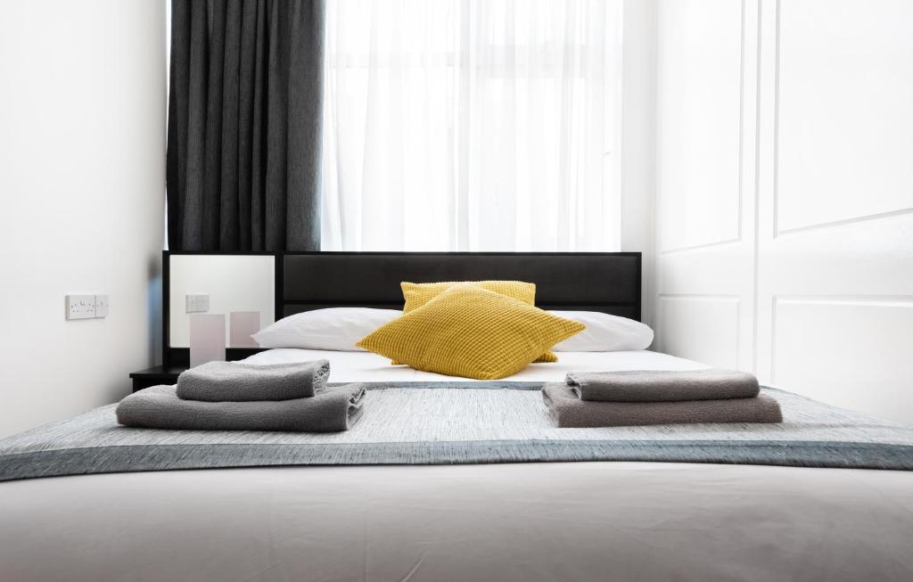 伦敦霍斯顿中央肖迪奇酒店的一间卧室配有一张带黄色枕头的大床