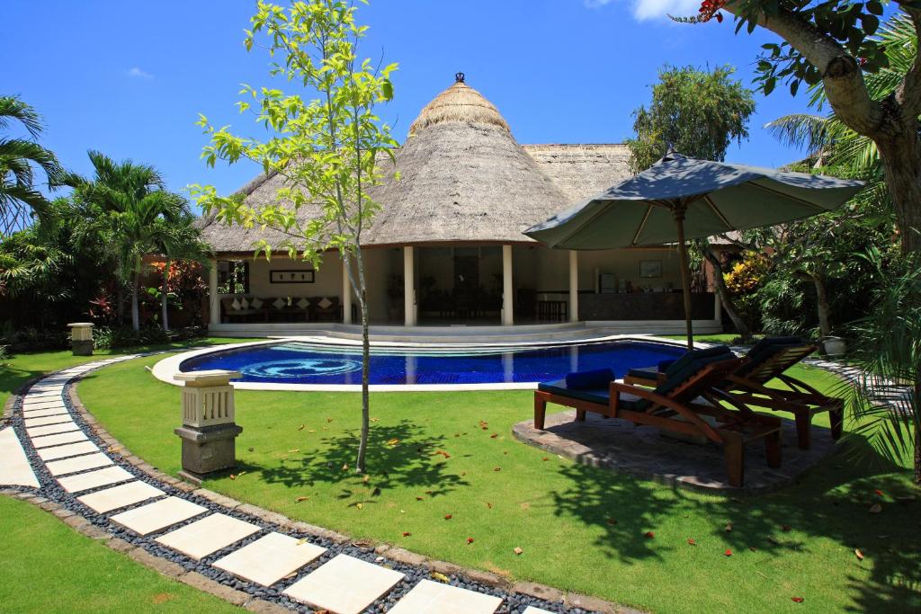 塞米亚克杜顺酒店的一座带游泳池、椅子和遮阳伞的房子