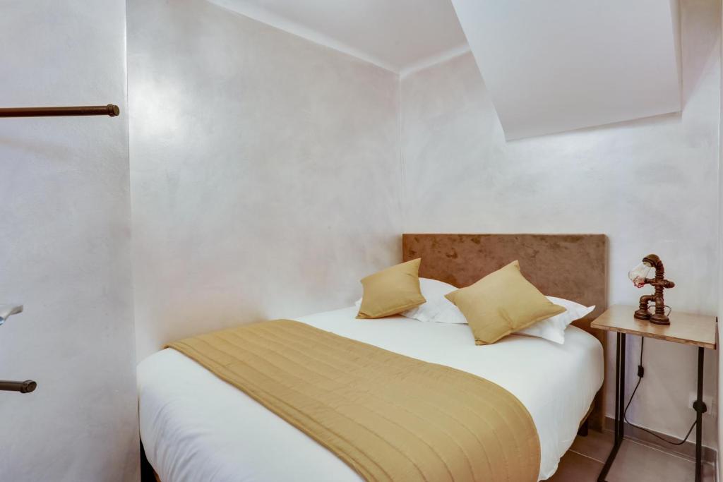 鲁瓦西昂法兰西Roissy Appartements的一间卧室配有白色床和黄色枕头