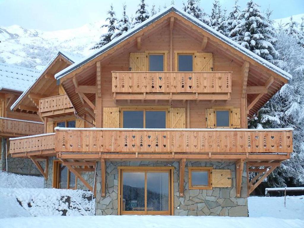 Saint-Pancrace索里尔及度假公寓式酒店的大型木屋,在雪地里设有阳台