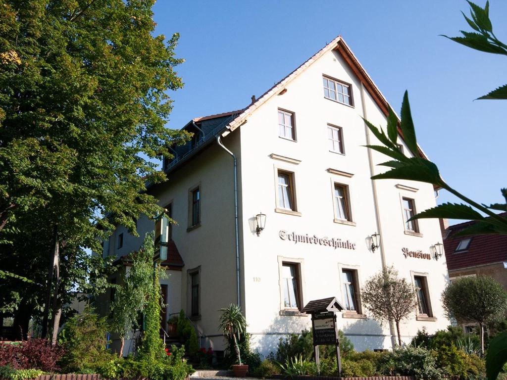 德累斯顿Pension Schmiedeschänke的前面有标志的白色建筑