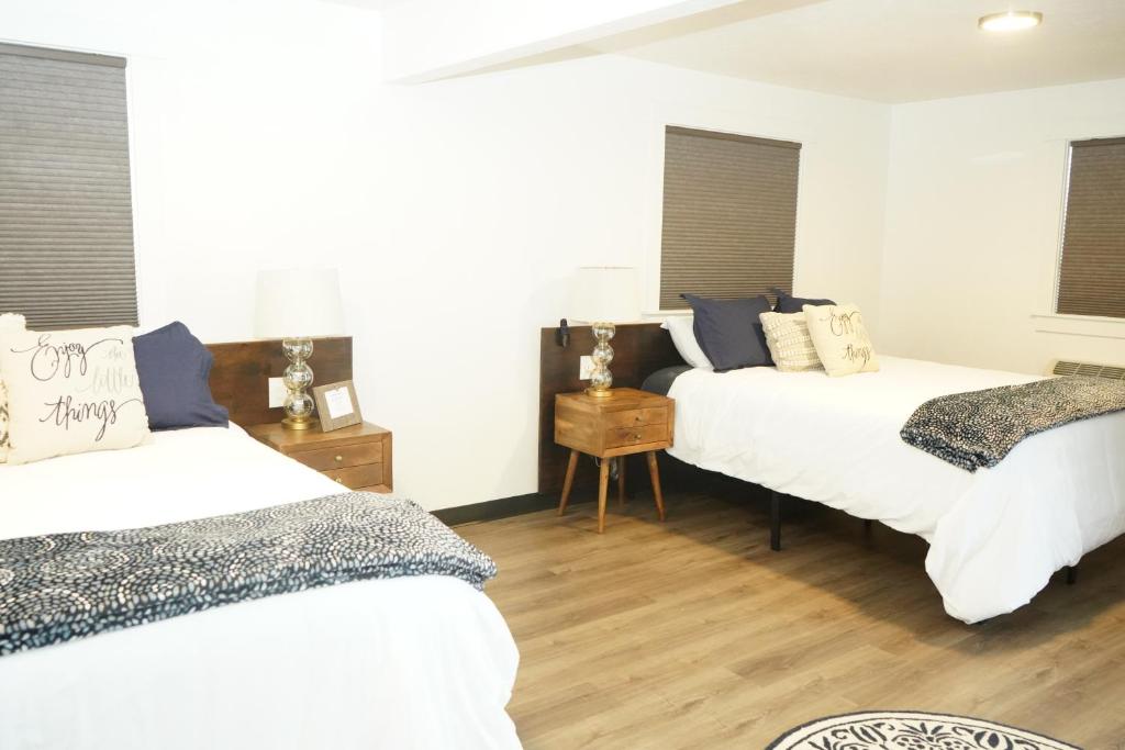 科达伦North Idaho Inn的客房内设有两张床,铺有木地板,设有窗户。