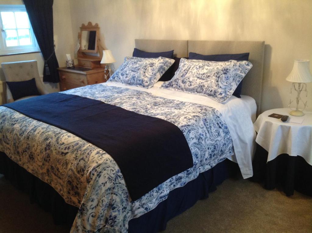 诺里奇Primrose Cottage的一间卧室配有一张带蓝白色床单的大床