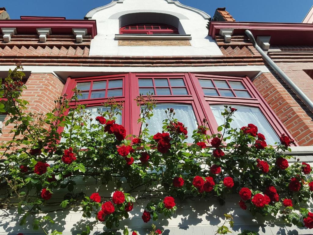 Hellemmes-Lille奥特劳巴朵酒店的建筑前的红玫瑰窗