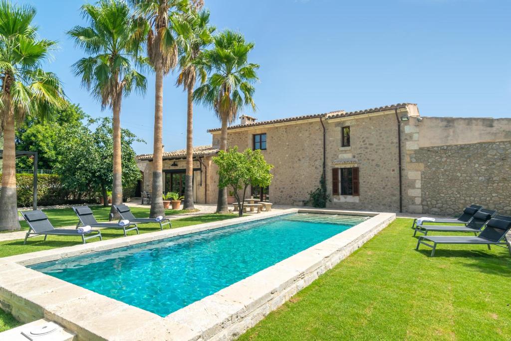 塞尔瓦S'Hort Des Capellà Verona的一个带椅子的游泳池以及一座房子