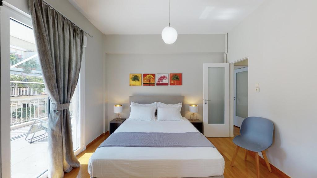 雅典Penthouse of light @ Koukaki的一间卧室设有一张床和一个大窗户