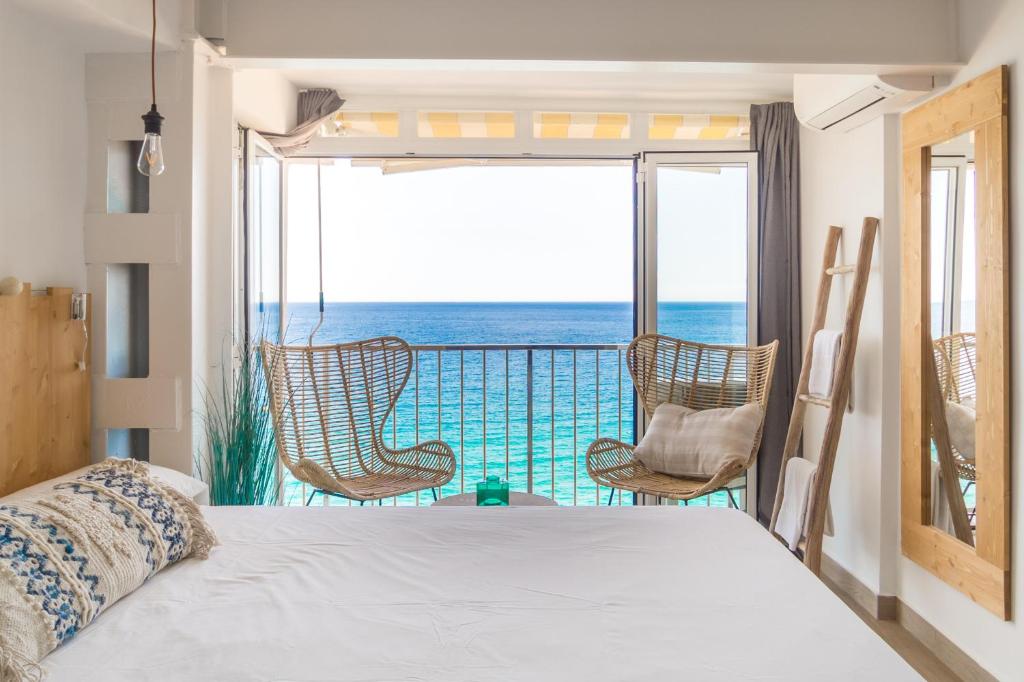 普拉加德阿罗Sugar Beach Boutique Studio的一间卧室设有一张床和一个海景阳台