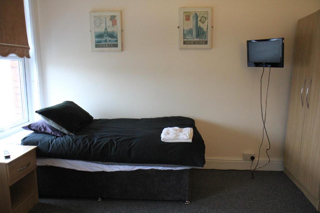 利物浦Clifton arms的卧室配有一张床铺,墙上配有电视