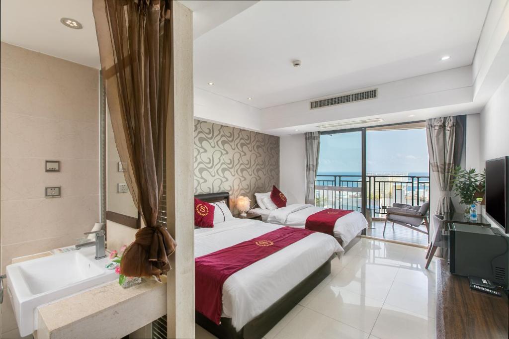 三亚三亚日月海旅租的酒店客房设有两张床、一个浴缸和一个浴缸。