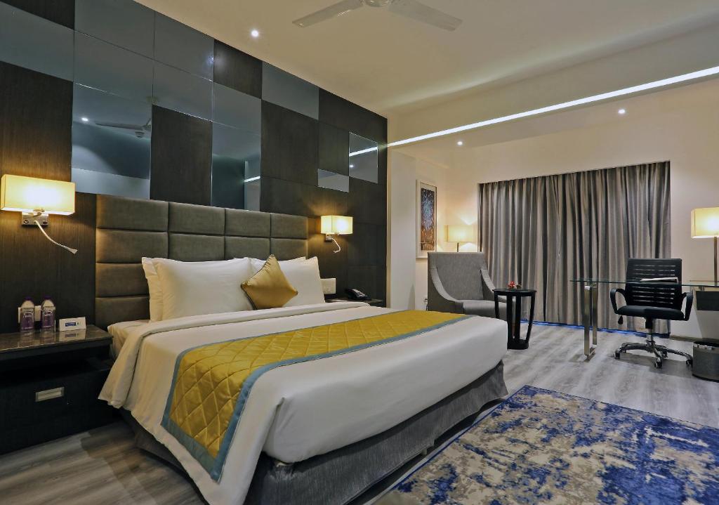 维沙卡帕特南Best Western Plus Tejvivaan的酒店客房设有一张大床和一张书桌。