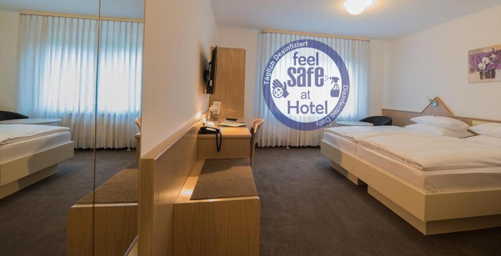 内卡河畔弗赖贝格艾玛瓦森酒店的酒店客房,设有两张床和标志