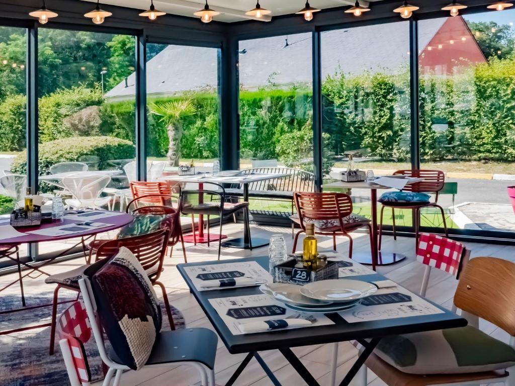 萨兰萨兰奥尔良北宜必思酒店的餐厅设有桌椅和窗户。