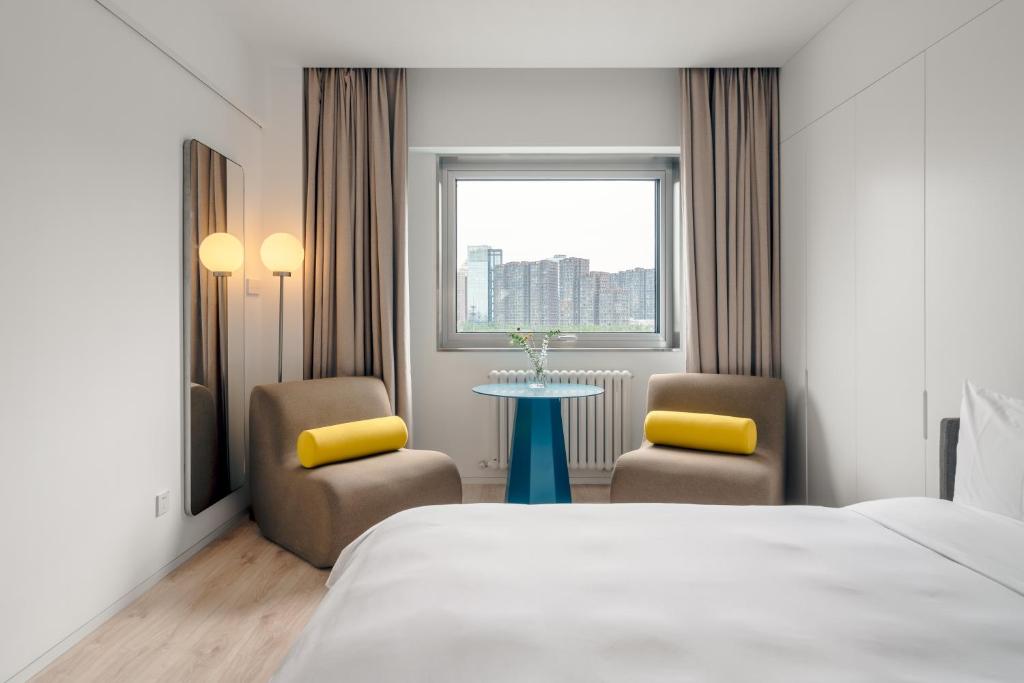 北京Stey酒店（北京望京798店）的酒店客房配有一张床、两把椅子和一张桌子
