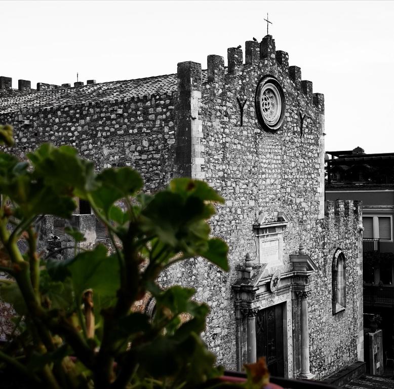 陶尔米纳Casa Viola - Al Centro的一座旧砖砌的建筑,上面有时钟