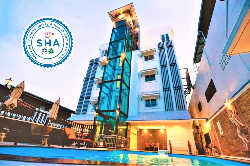 华欣Hua Hin White Villa Hotel - SHA Certified的大楼前设有游泳池的酒店