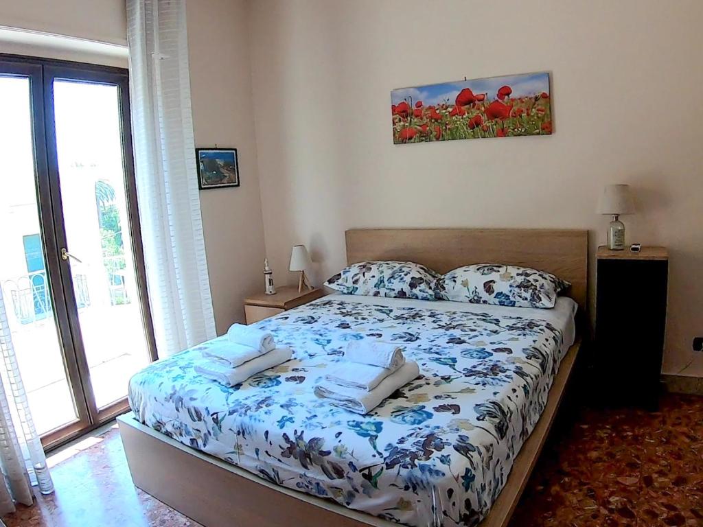 雷焦卡拉布里亚La Casa di Aurora的一间卧室配有一张带蓝色和白色棉被的床