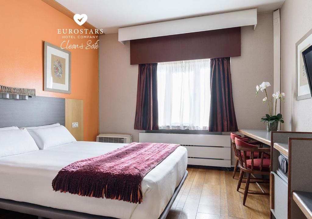 莱昂Crisol Quindós的酒店客房设有一张大床和一张书桌。