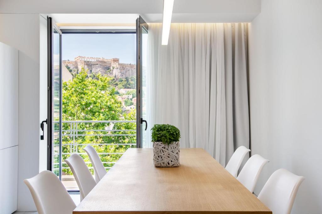 雅典NS PLACE Modern Apartment Acropolis view的一间带桌椅和大窗户的用餐室