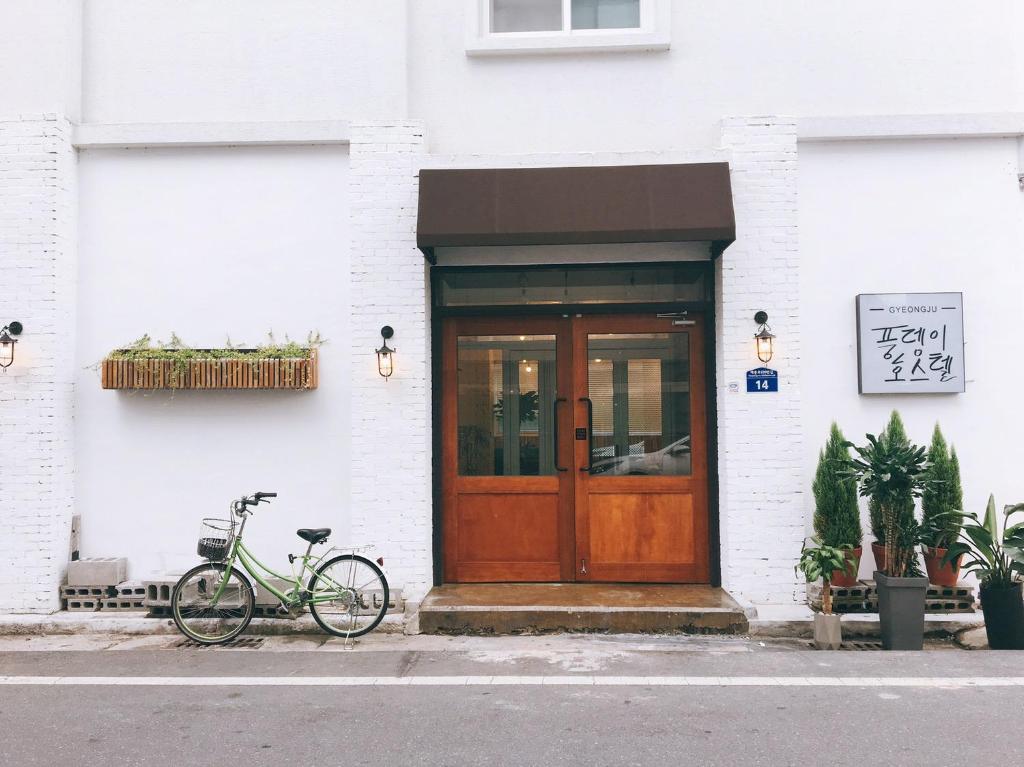 庆州Minihotel Poongdaengi的停在大楼前的自行车,有门