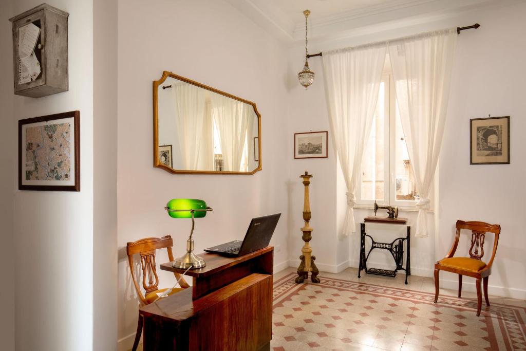 罗马Guesthouse Serafino的客房设有带笔记本电脑和镜子的书桌。