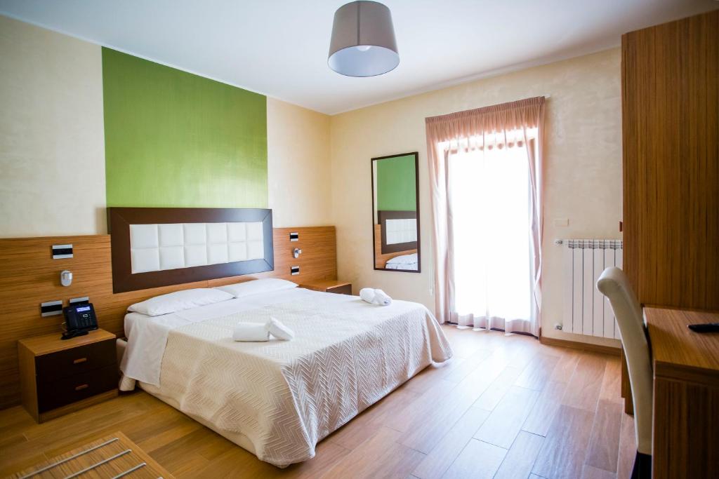 卡普拉科塔Hotel Monte Campo的一间卧室设有一张大床和一个大窗户