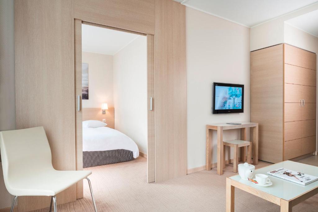 日内瓦Starling Hôtel Résidence Genève的酒店客房,配有床和镜子