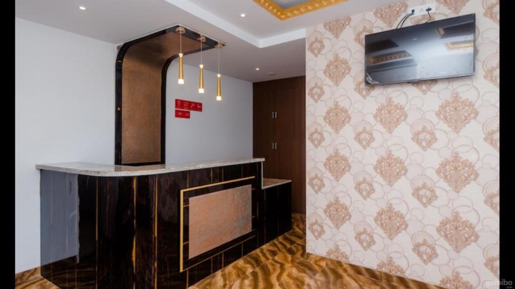孟买Hotel Embassy Suites - Bandra Kurla Complex - BKC Mumbai的一间设有壁挂式电视和壁炉的客房