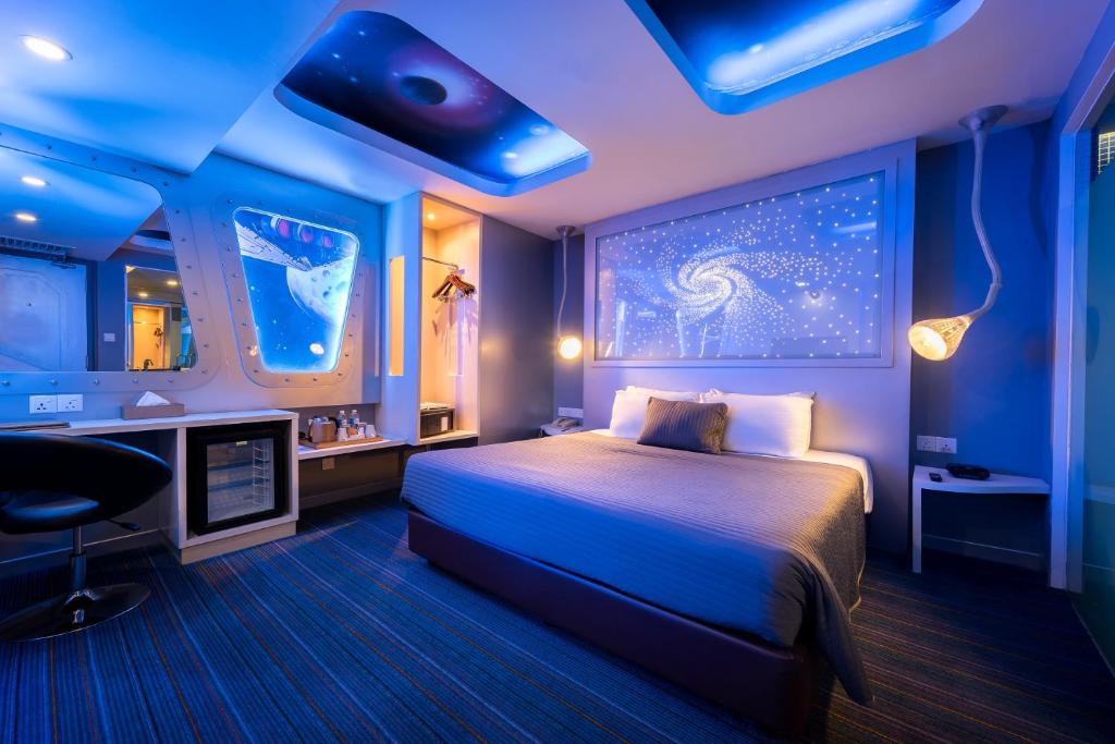 吉隆坡Maison Boutique Theme Hotel Kuala Lumpur by Swing & Pillows的一间设有床铺的卧室,位于蓝色灯光的房间