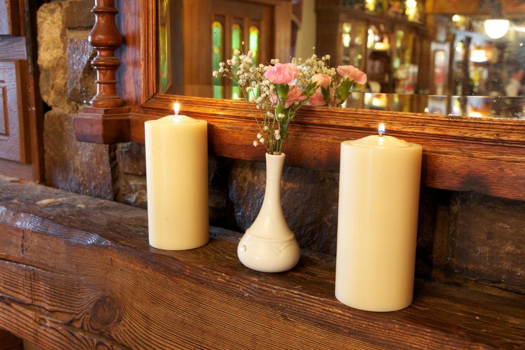 阿比菲尔雷恩斯酒店的三个蜡烛和一个花瓶在柜台上