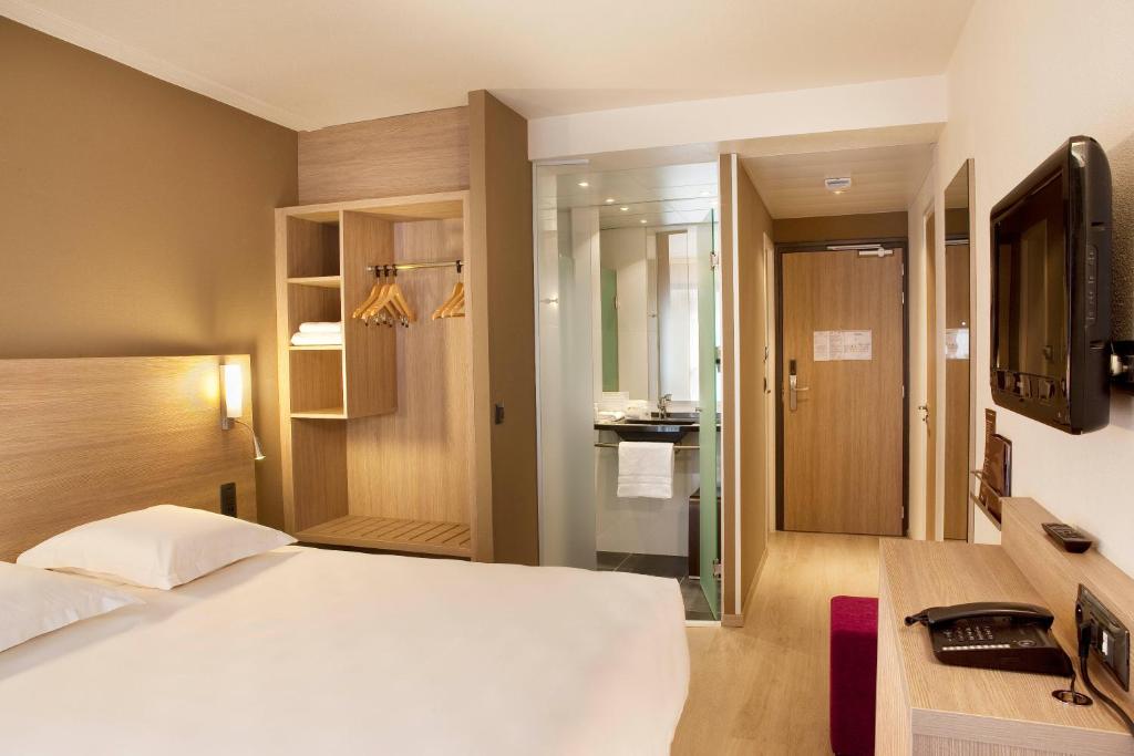 坎佩尔坎佩尔中心大洋洲艾思格尔酒店的一间带白色床的卧室和一间浴室