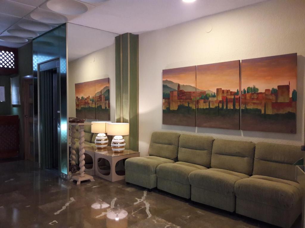 兰哈龙Hotel Paraíso的客厅配有沙发和墙上的绘画