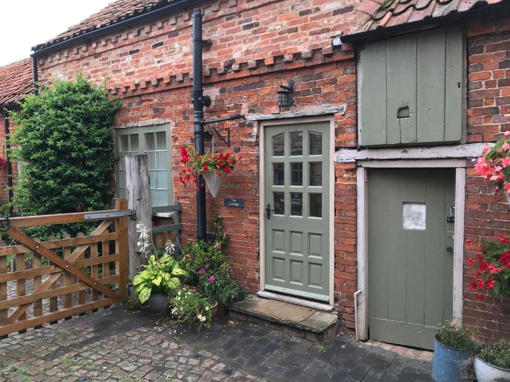 BottesfordBottesford Cottage - Leicestershire的砖屋,有两扇门和栅栏