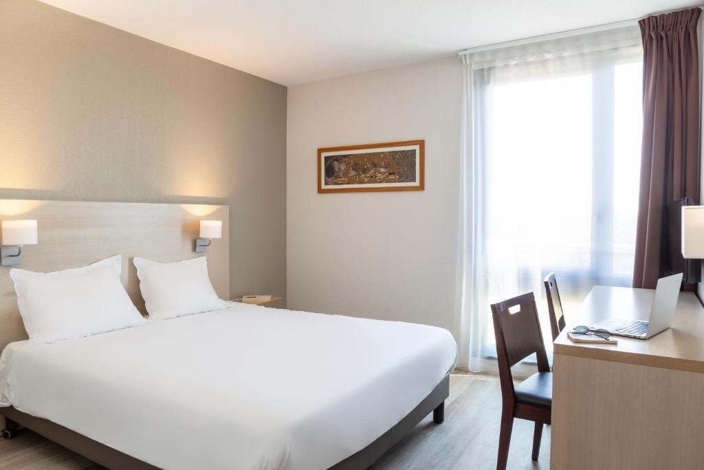 阿维尼翁阿维尼翁阿德吉奥阿克瑟斯公寓式酒店的酒店客房设有一张白色大床和一张书桌