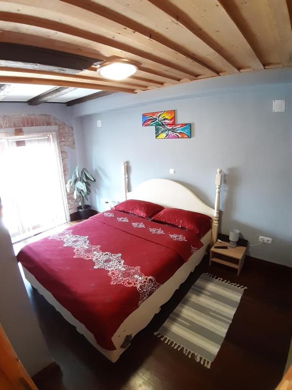 锡比乌Apartament Mario的一间卧室设有红色的床和窗户。