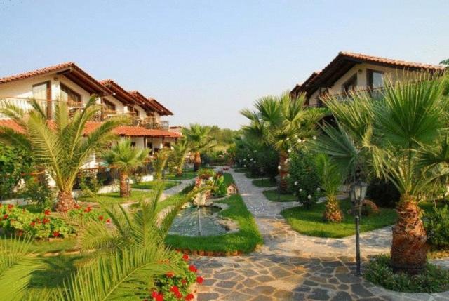 普里诺斯Oneiro Zois villas的棕榈树和鲜花环绕的度假庭院
