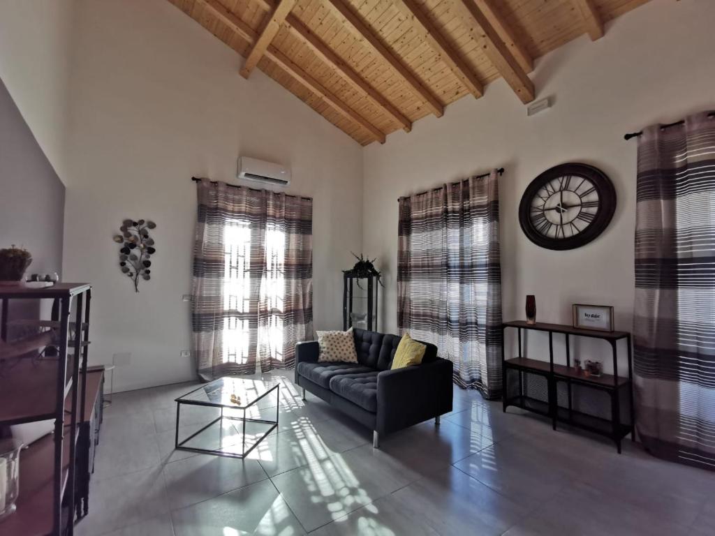 卡塔尼亚Hygge House Catania的客厅配有沙发和墙上的时钟