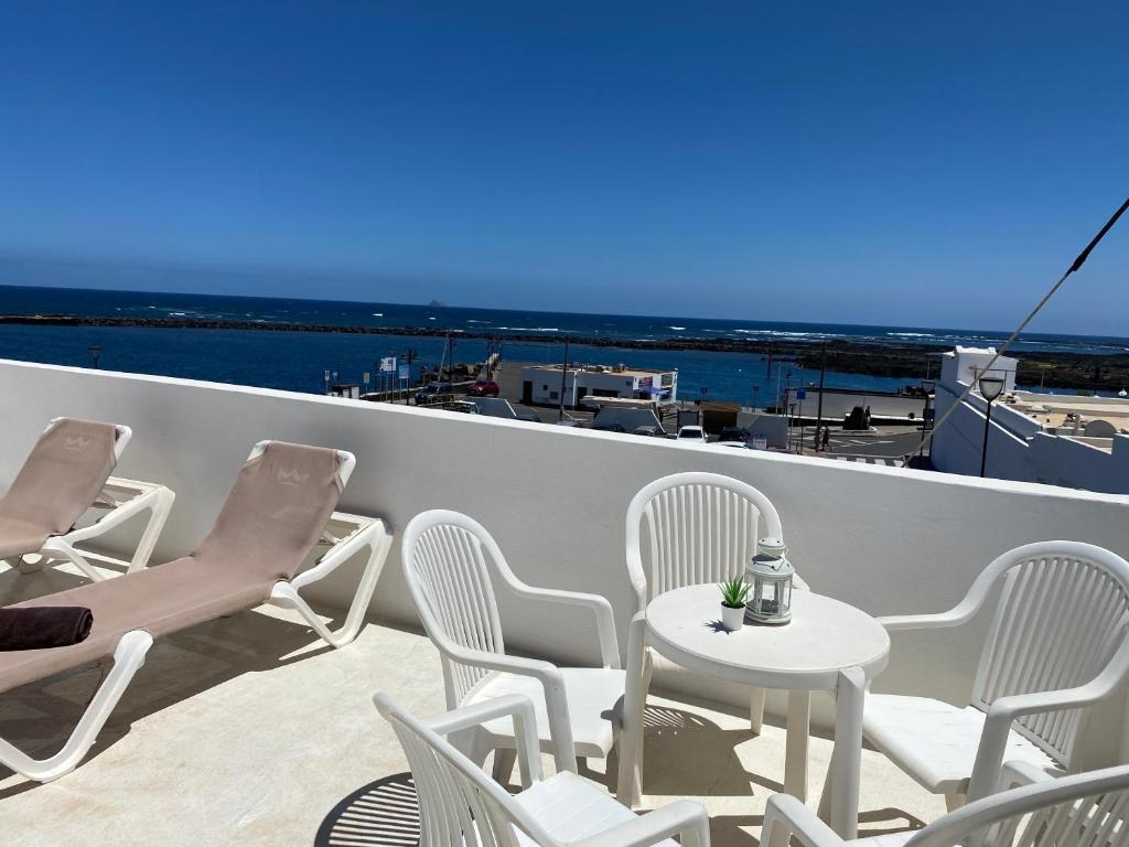 奥尔索拉Mirador del muelle house的阳台配有桌椅,享有海景。